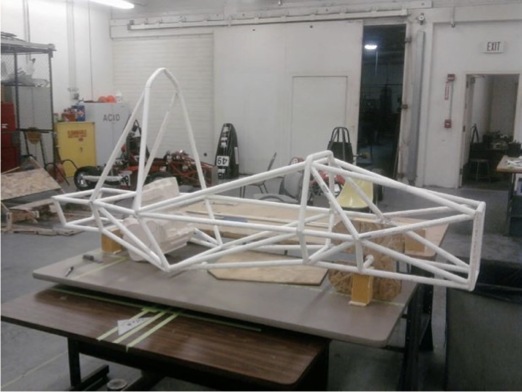 Physical tubular chassis prototype positioned on a workshop bench